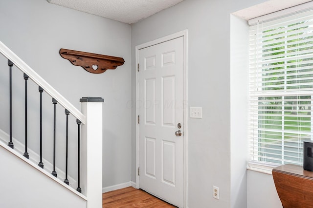 5120 Singleton Dr Unit 36D, Hilliard, OH 43026 - entryway with light wood-style flooring, stairway, a textured ceiling, and baseboards