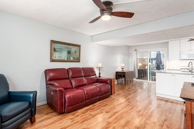 5120 Singleton Dr Unit 36D, Hilliard, OH 43026 - living area with light wood-style flooring, a ceiling fan, a textured ceiling, and baseboards
