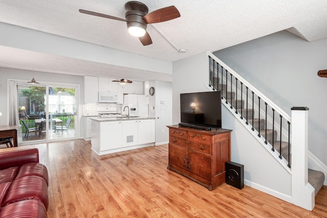 5120 Singleton Dr Unit 36D, Hilliard, OH 43026 - living area with a ceiling fan, light wood-style floors, a textured ceiling, stairway, and baseboards