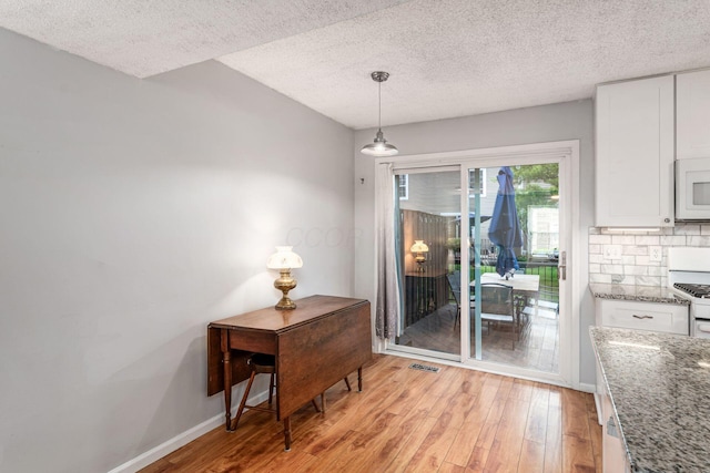 5120 Singleton Dr Unit 36D, Hilliard, OH 43026 - dining area featuring light wood-style flooring, baseboards, and a textured ceiling