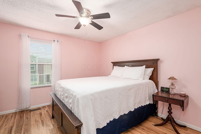 5120 Singleton Dr Unit 36D, Hilliard, OH 43026 - bedroom featuring light wood-type flooring, baseboards, a textured ceiling, and a ceiling fan