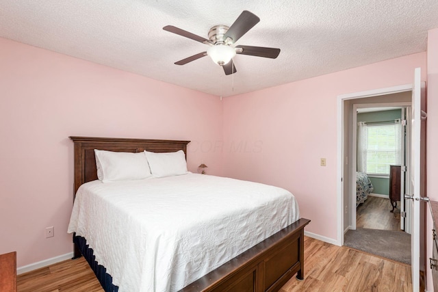 5120 Singleton Dr Unit 36D, Hilliard, OH 43026 - bedroom featuring light wood-type flooring, baseboards, a textured ceiling, and a ceiling fan