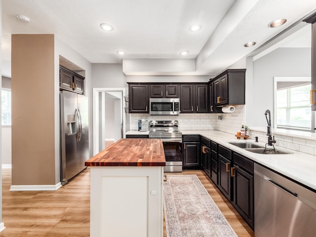 4710 Helmsbridge Ct, Grove City, OH 43123 - kitchen with appliances with stainless steel finishes, a sink, wooden counters, decorative backsplash, and light wood-style flooring