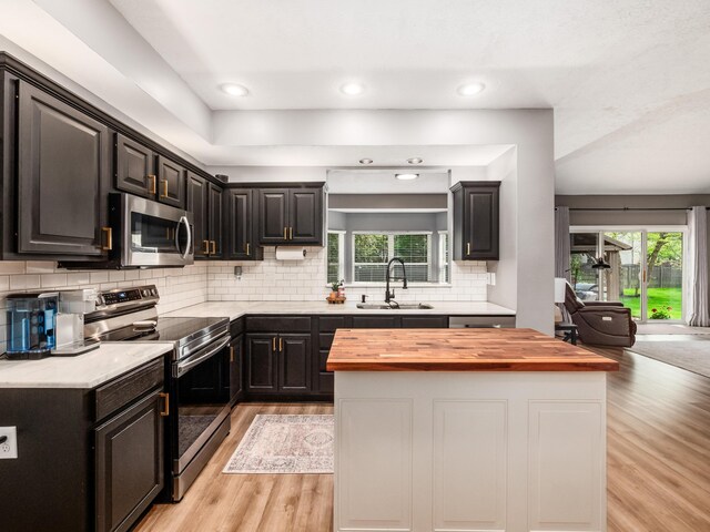 4710 Helmsbridge Ct, Grove City, OH 43123 - kitchen featuring appliances with stainless steel finishes, butcher block countertops, a sink, light wood-style floors, and tasteful backsplash