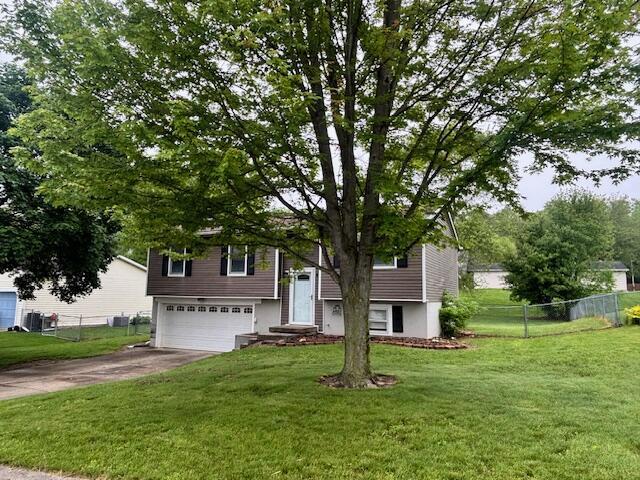 bi-level home with an attached garage and driveway