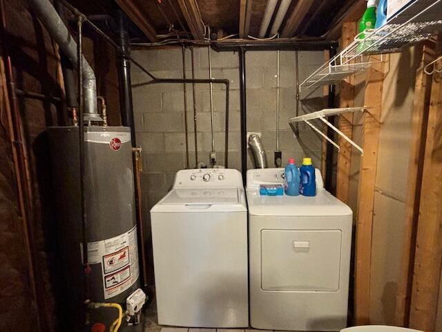 laundry room with water heater and washing machine and dryer