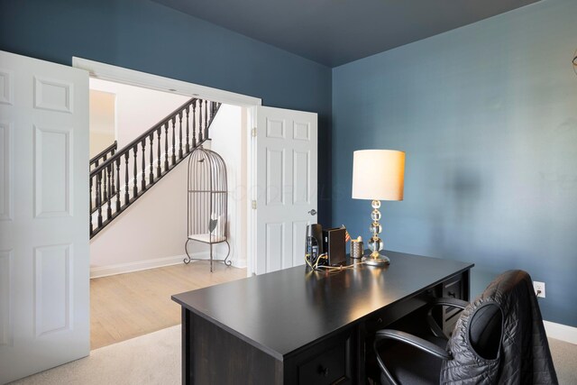 office space with baseboards and light wood-style flooring