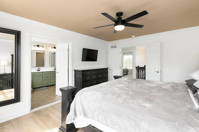 bedroom with crown molding, light wood-style floors, ceiling fan, ensuite bath, and baseboards