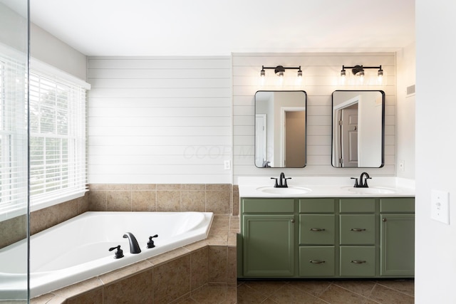 bathroom with double vanity, a bath, and tile patterned floors