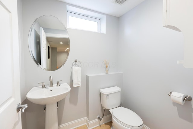 half bath with toilet and baseboards
