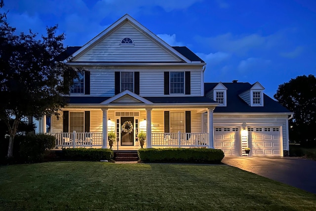 view of front facade with covered porch, concrete driveway, a front lawn, and a garage