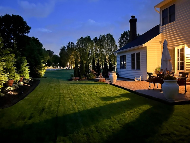 view of green lawn with a patio