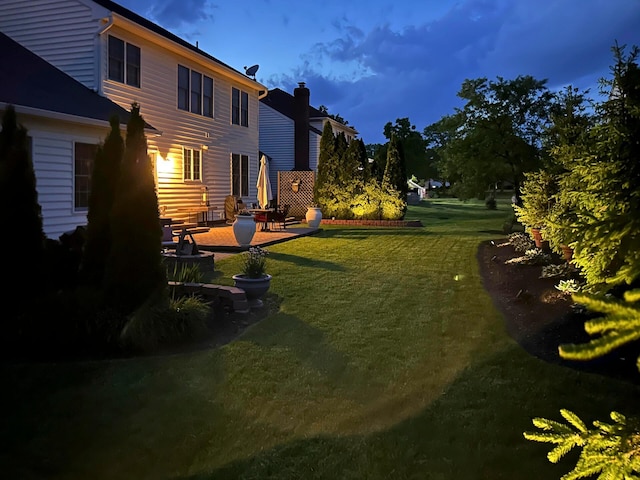 view of green lawn featuring a patio area