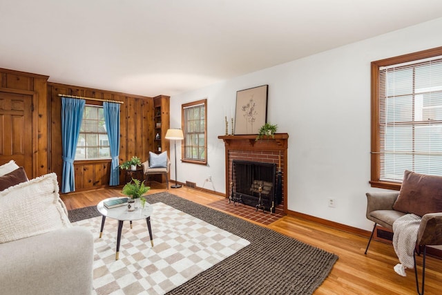 living room with healthy amount of natural light, light wood-style floors, wood walls, and baseboards