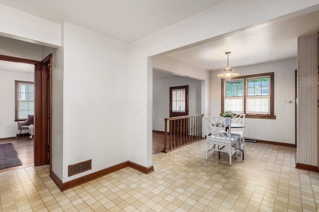 dining space with baseboards, healthy amount of natural light, and wallpapered walls