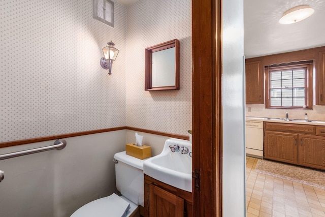 bathroom with wallpapered walls, toilet, vanity, and tile patterned floors