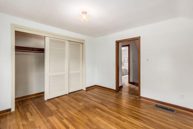 unfurnished bedroom featuring a closet, light wood-style floors, and baseboards