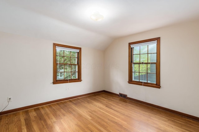 bonus room with vaulted ceiling, light wood-style floors, plenty of natural light, and baseboards