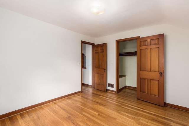 unfurnished bedroom featuring baseboards, a closet, and light wood-type flooring
