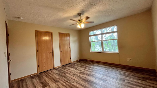5332 Wadley Ct, Canal Winchester, OH 43110 - unfurnished bedroom featuring multiple closets, wood finished floors, a textured ceiling, and baseboards