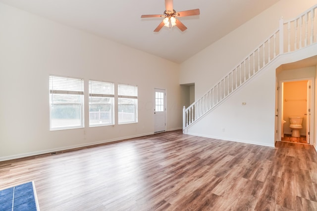 5332 Wadley Ct, Canal Winchester, OH 43110 - unfurnished living room with stairway, wood finished floors, a towering ceiling, and ceiling fan