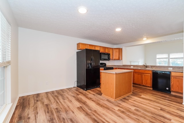 5332 Wadley Ct, Canal Winchester, OH 43110 - kitchen with black appliances, a textured ceiling, light wood-type flooring, light countertops, and a kitchen island