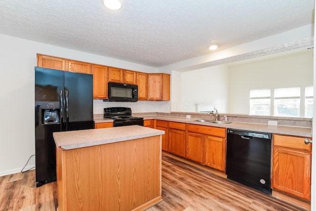 5332 Wadley Ct, Canal Winchester, OH 43110 - kitchen featuring black appliances, light wood finished floors, light countertops, a textured ceiling, and a kitchen island