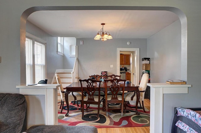 1306-1308 Wilson Ave, Columbus, OH 43206 - dining space with arched walkways, light wood-style flooring, and a chandelier