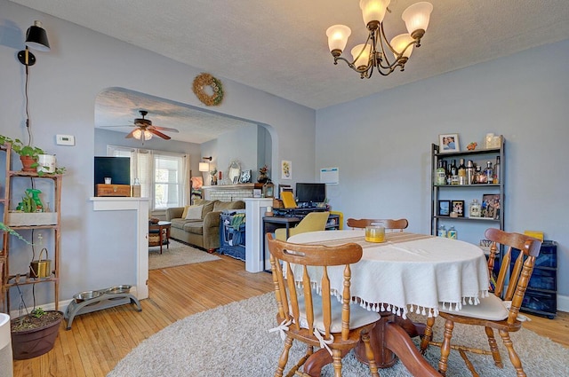 1306-1308 Wilson Ave, Columbus, OH 43206 - dining space featuring arched walkways, a chandelier, light wood-style flooring, ceiling fan, and a textured ceiling