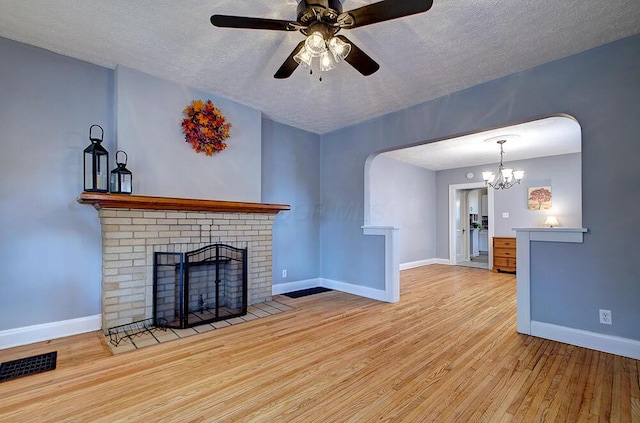 1306-1308 Wilson Ave, Columbus, OH 43206 - unfurnished living room featuring wood finished floors, baseboards, a fireplace, a textured ceiling, and arched walkways