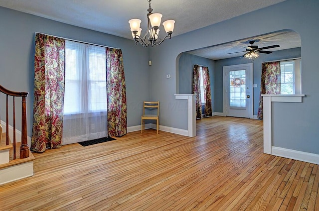 1306-1308 Wilson Ave, Columbus, OH 43206 - unfurnished dining area with arched walkways, baseboards, light wood-style flooring, and stairs