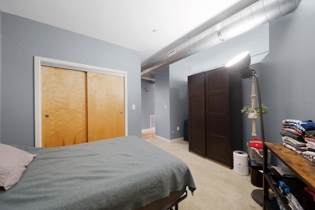 bedroom featuring light colored carpet and a closet