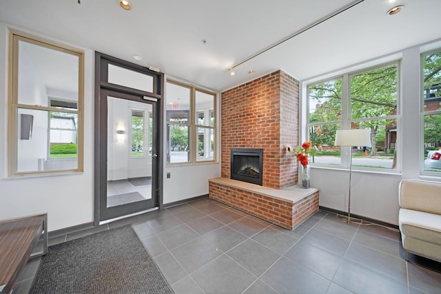 living room featuring plenty of natural light, dark tile patterned floors, and a fireplace