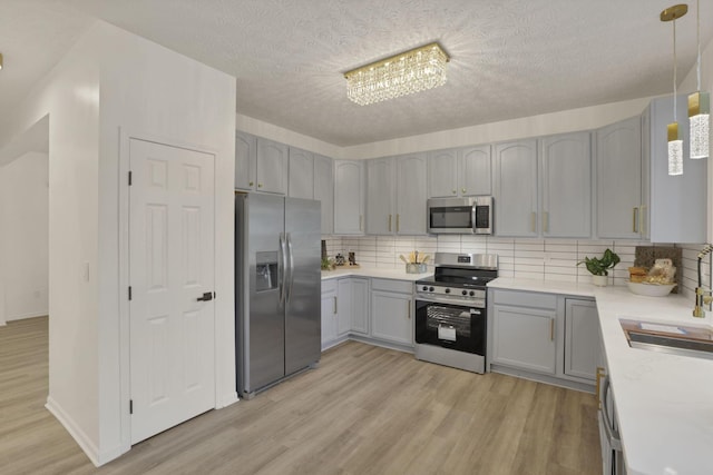 3907 Winding Path Dr, Canal Winchester, OH 43110 - kitchen with appliances with stainless steel finishes, gray cabinets, light wood-style floors, and a textured ceiling