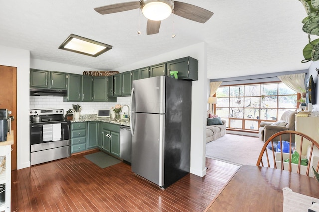 230 Clover Ct, Newark, OH 43055 - kitchen with stainless steel appliances, green cabinetry, under cabinet range hood, open floor plan, and dark wood-style flooring