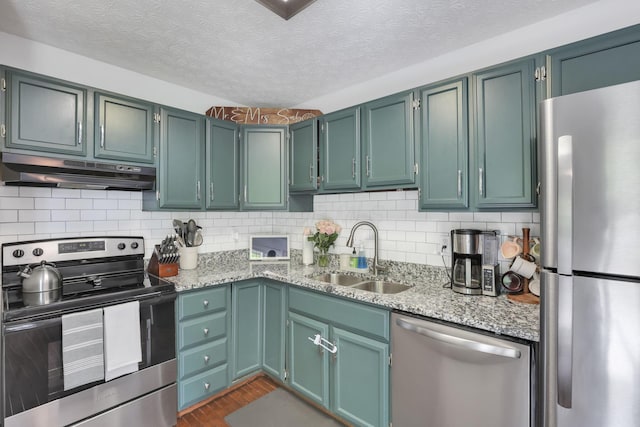 230 Clover Ct, Newark, OH 43055 - kitchen with stainless steel appliances, under cabinet range hood, a sink, dark wood-style floors, and light stone countertops