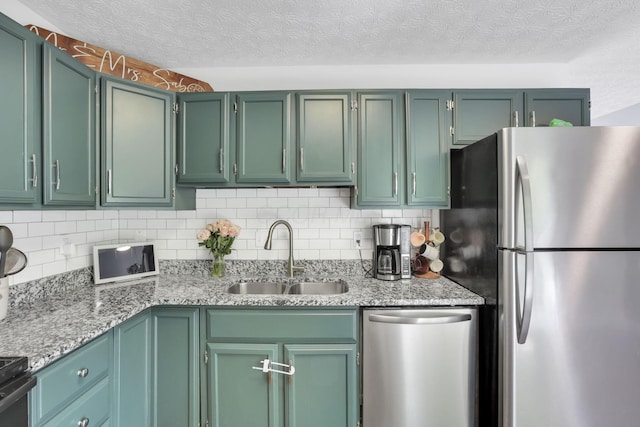 230 Clover Ct, Newark, OH 43055 - kitchen with appliances with stainless steel finishes, a sink, tasteful backsplash, light stone countertops, and a textured ceiling