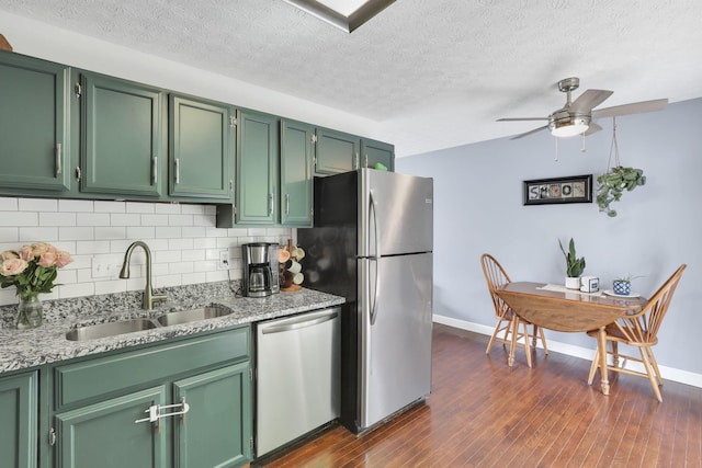 230 Clover Ct, Newark, OH 43055 - kitchen featuring stainless steel appliances, a sink, green cabinets, tasteful backsplash, and a textured ceiling
