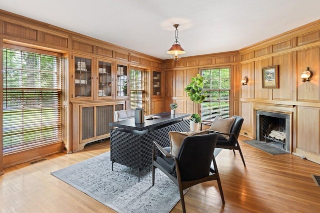 324 E N Broadway St, Columbus, OH 43214 - dining area featuring plenty of natural light, wood walls, a fireplace with flush hearth, light wood-type flooring, and a decorative wall