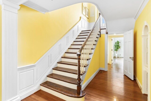 324 E N Broadway St, Columbus, OH 43214 - stairway featuring wood finished floors, ornamental molding, baseboards, and arched walkways