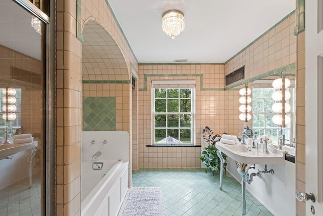324 E N Broadway St, Columbus, OH 43214 - bathroom with a bath, tile patterned flooring, and tile walls