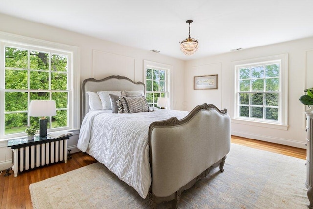 324 E N Broadway St, Columbus, OH 43214 - bedroom featuring radiator, multiple windows, and wood finished floors