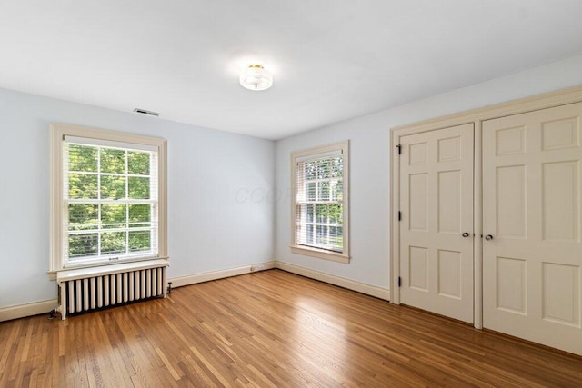 324 E N Broadway St, Columbus, OH 43214 - unfurnished bedroom with radiator, light wood finished floors, and baseboards