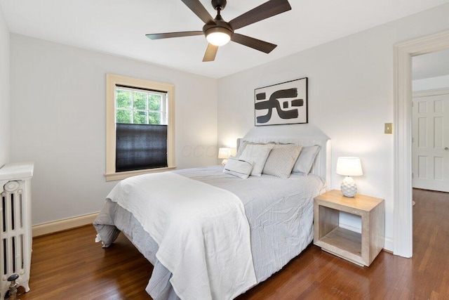 324 E N Broadway St, Columbus, OH 43214 - bedroom featuring radiator heating unit, dark wood-type flooring, baseboards, and ceiling fan