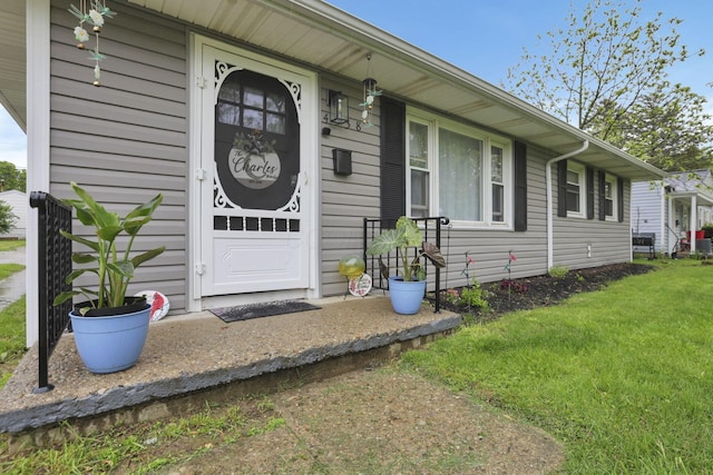 doorway to property featuring a lawn