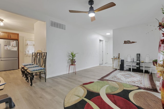 living area with ceiling fan, light wood-style flooring, and baseboards