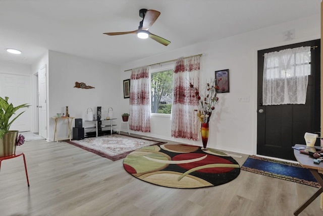foyer entrance with wood finished floors, baseboards, and a ceiling fan