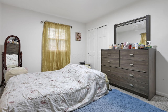 carpeted bedroom with a closet and baseboards