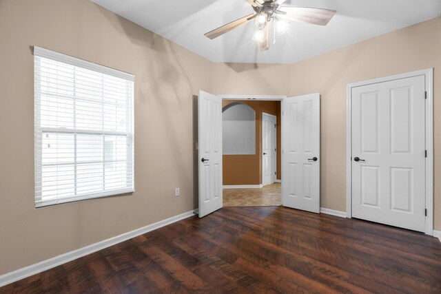 9032 Polaris Lakes Dr, Columbus, OH 43240 - unfurnished bedroom featuring multiple windows, baseboards, dark wood-type flooring, and ceiling fan