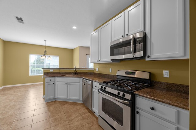 9032 Polaris Lakes Dr, Columbus, OH 43240 - kitchen with stainless steel appliances, a sink, a peninsula, baseboards, and white cabinetry